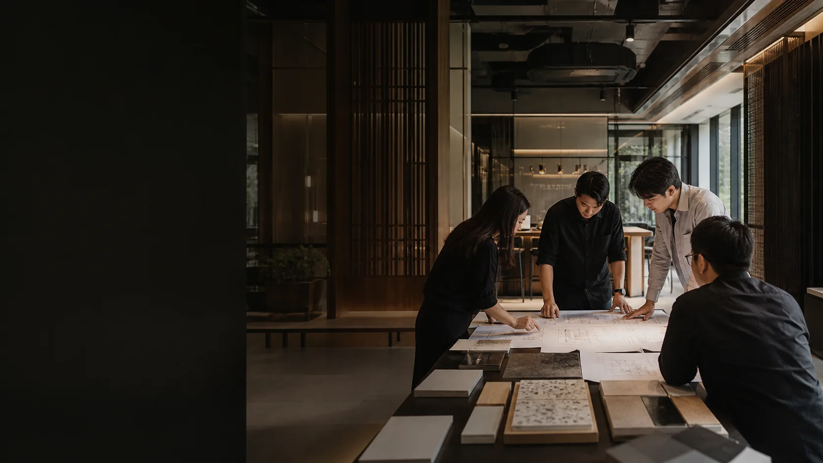 Interior design and fit-out team reviewing architectural drawings and material samples