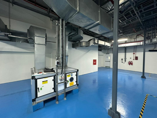 Industrial facility with coordinated mechanical services and blue epoxy flooring