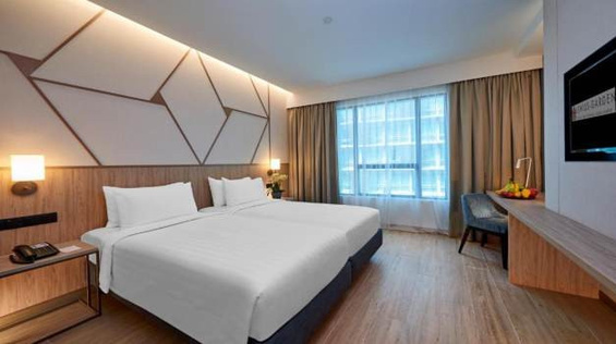 Hotel guest room with upholstered headboard and window seating
