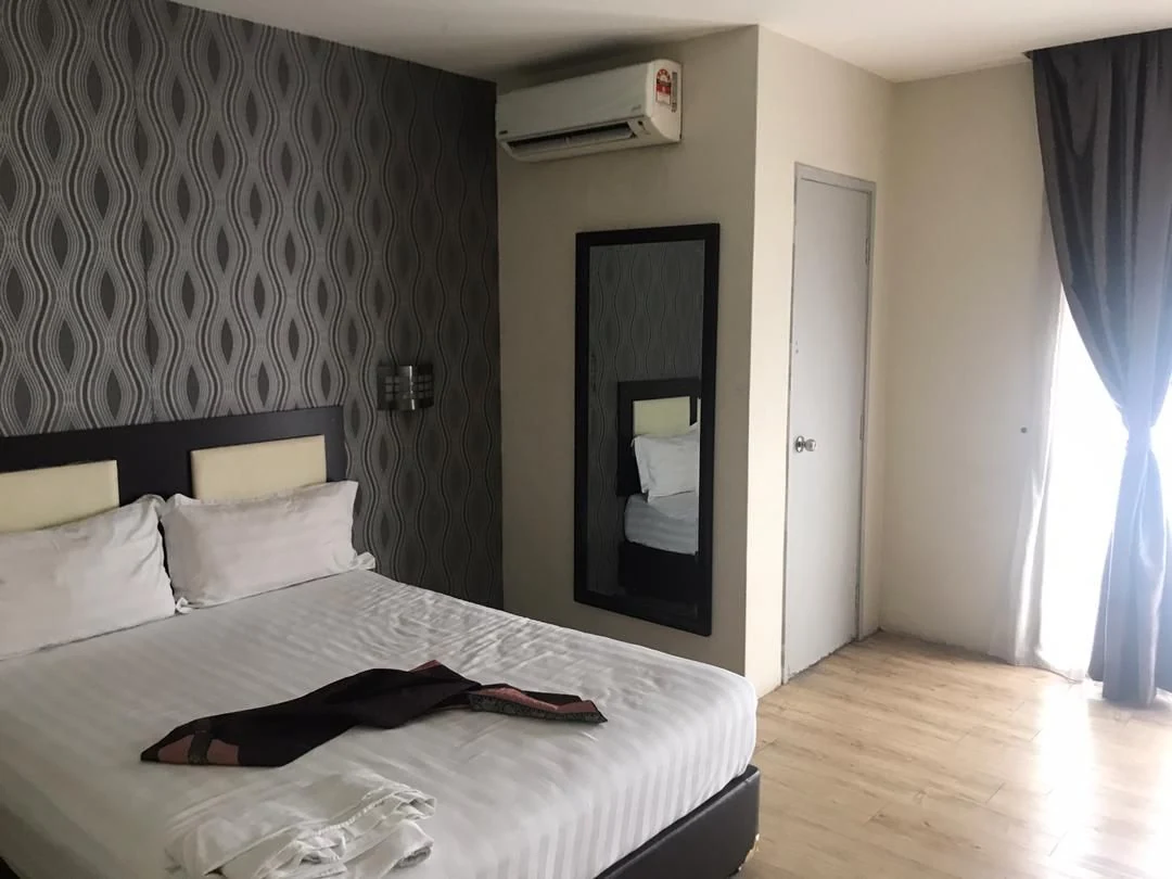 Completed boutique hotel guest room with patterned feature wall and fitted mirror