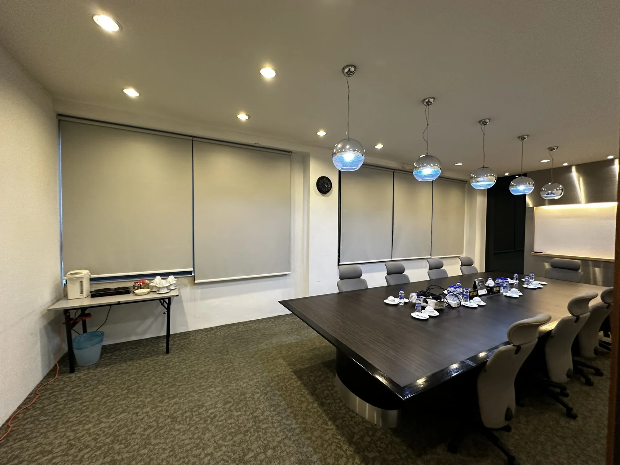 Completed corporate meeting room with a long conference table and fitted display wall