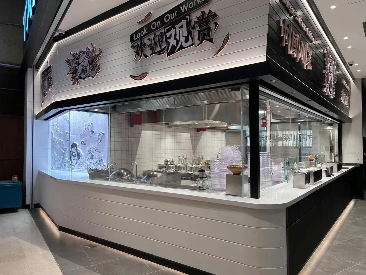 Completed Sichuan restaurant interior with open kitchen counter, fitted seating and feature lighting